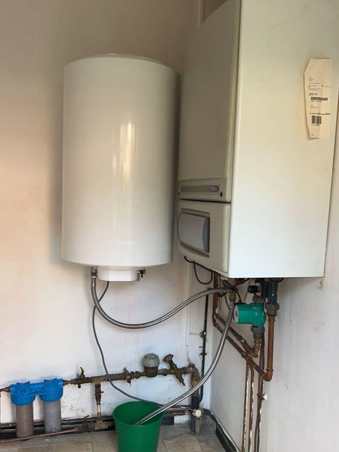 Ancien boiler mural et chaudière murale beige, avec des flexibles apparents