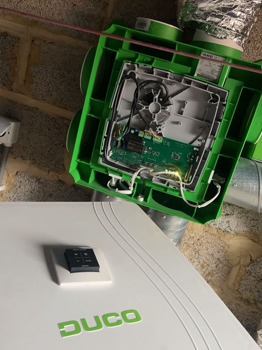 Caisson de ventilation ouvert en combles, gaines souples raccordées et commande murale